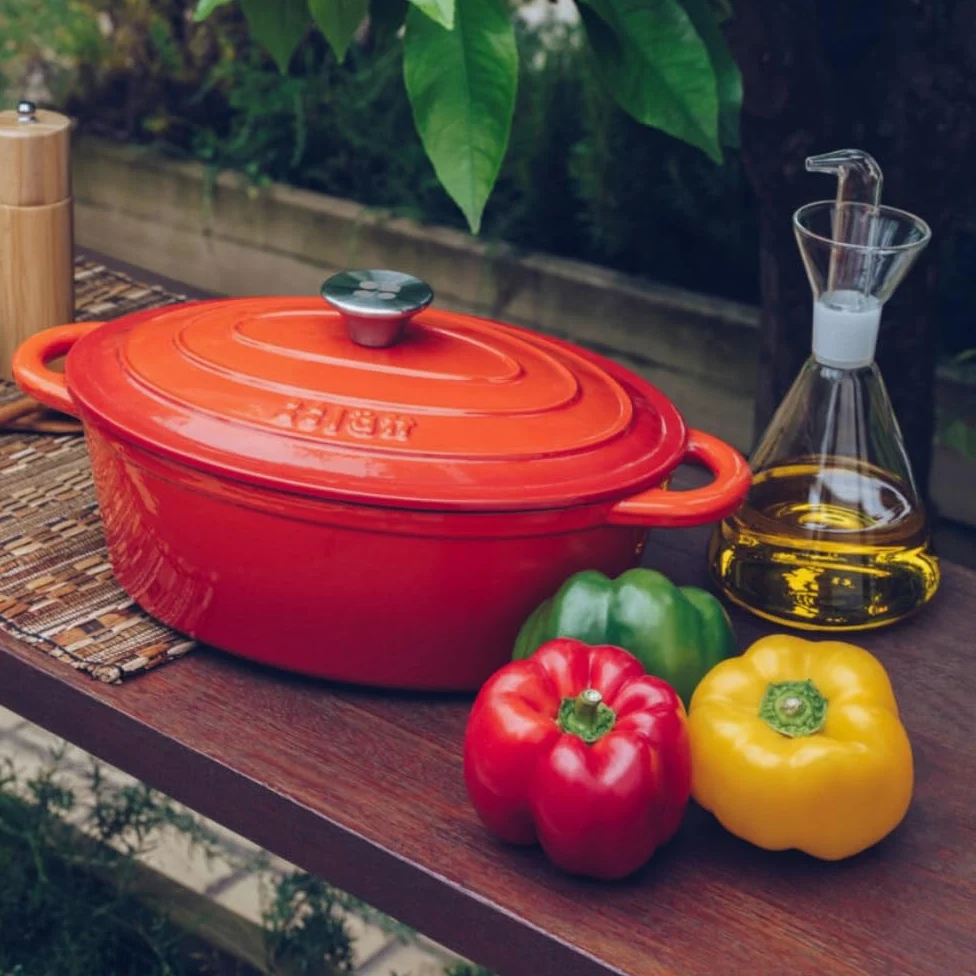 Cocotte in Ghisa Smaltata Arancione. Forno Olandese Pentola Ovale Antiaderente 29x21x11 CM - 3,85 L. Casseruola Pentola in Ferro per Induzione, Vetroceramica e Forno